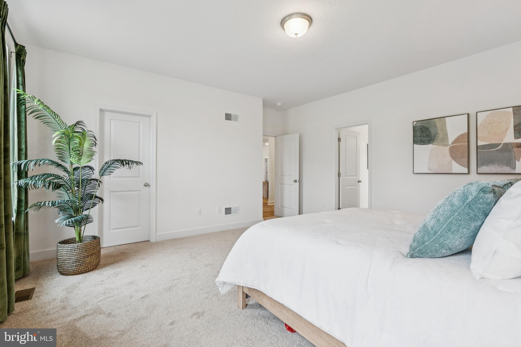 150 Piedmont Way, Unit 101 Hanover, PA 17331 - Photo 26 of 40 a bedroom with a bed and a potted plant