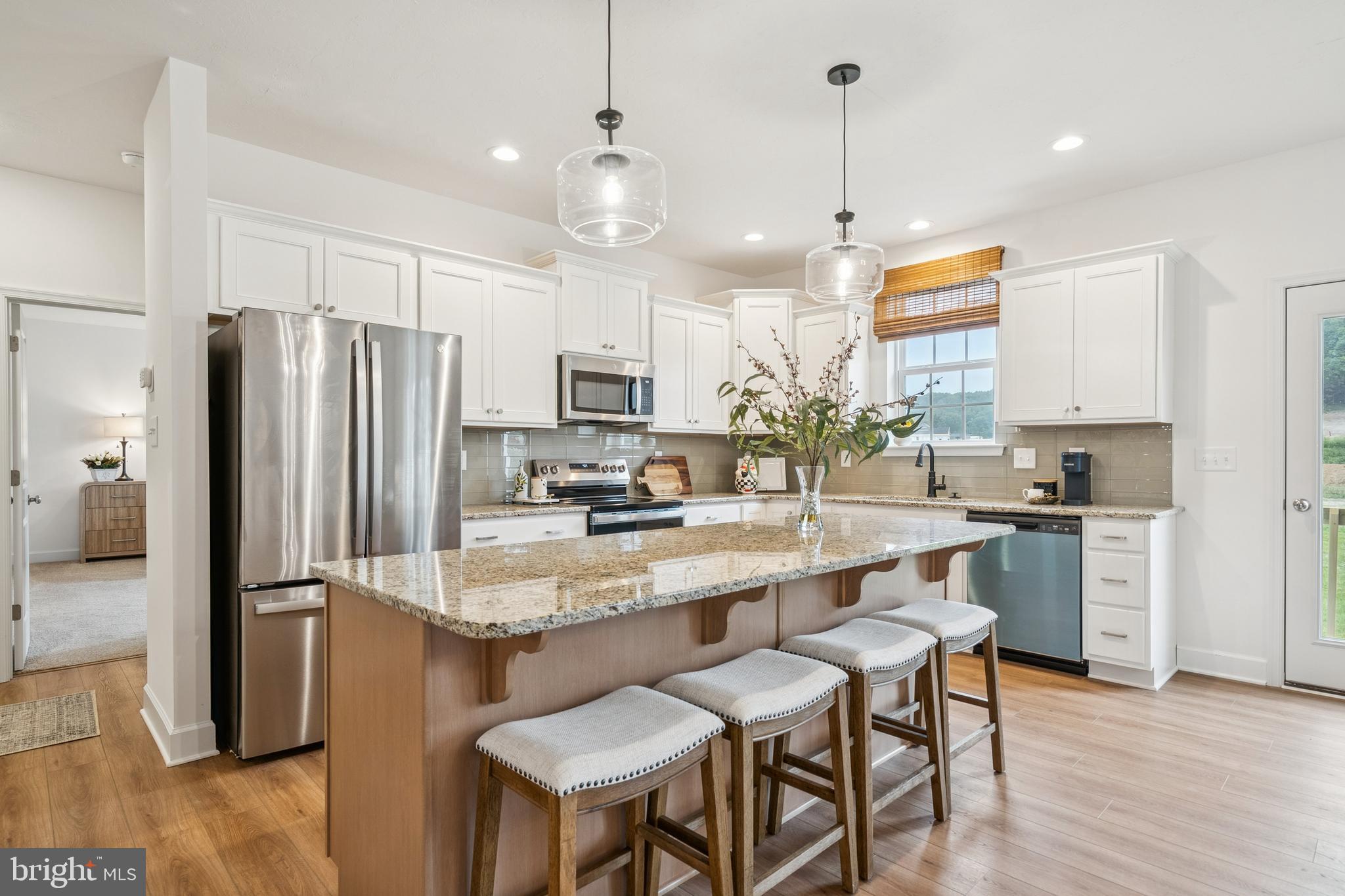 150 Piedmont Way, Unit 101 Hanover, PA 17331 - Photo 7 of 40 a kitchen with kitchen island a refrigerator a stove a sink and chairs