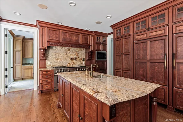 a kitchen with kitchen island a counter top space a sink stainless steel appliances and cabinets