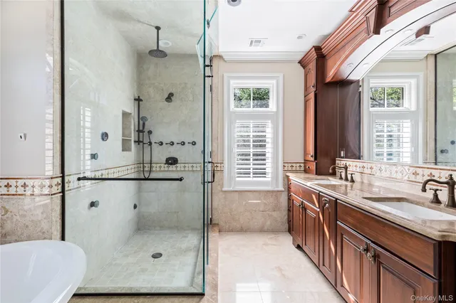a bathroom with a tub sink shower and mirror