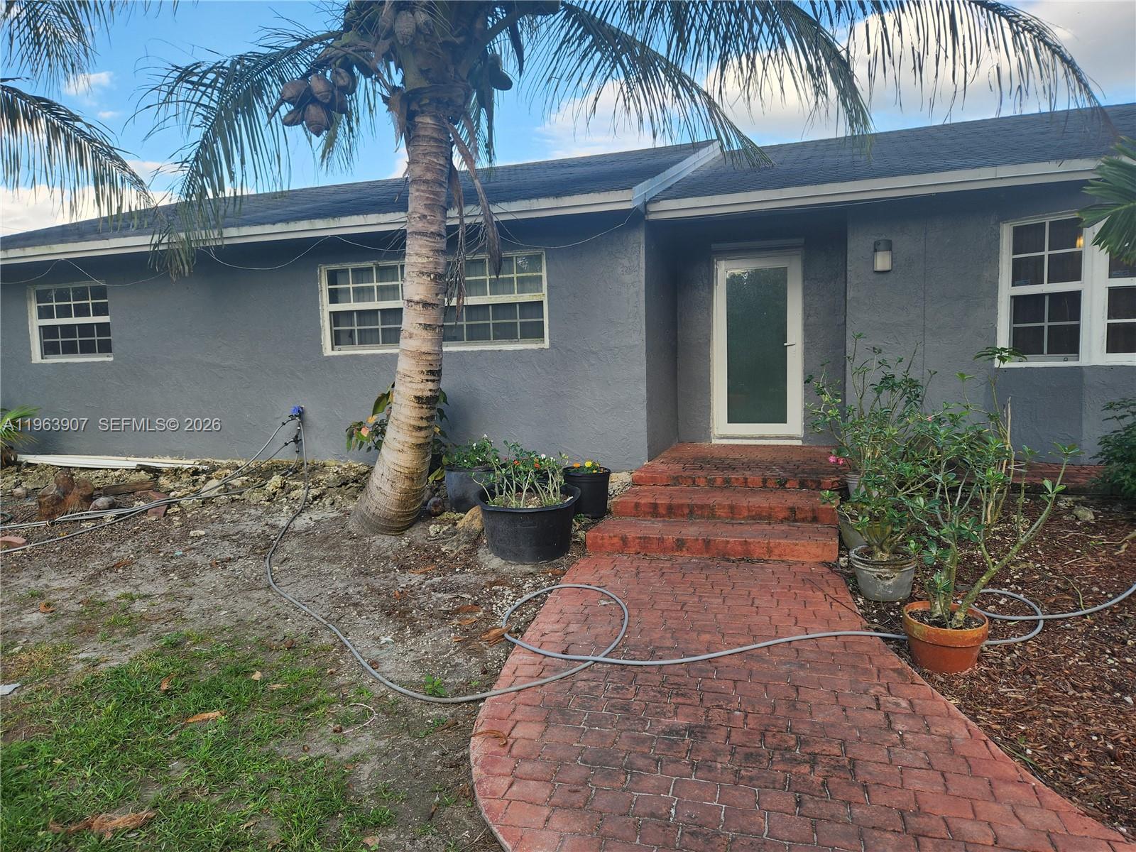 23801 Southwest 217th Avenue Homestead, FL 33031 - Photo 3 of 14 a front view of house with yard and trees around