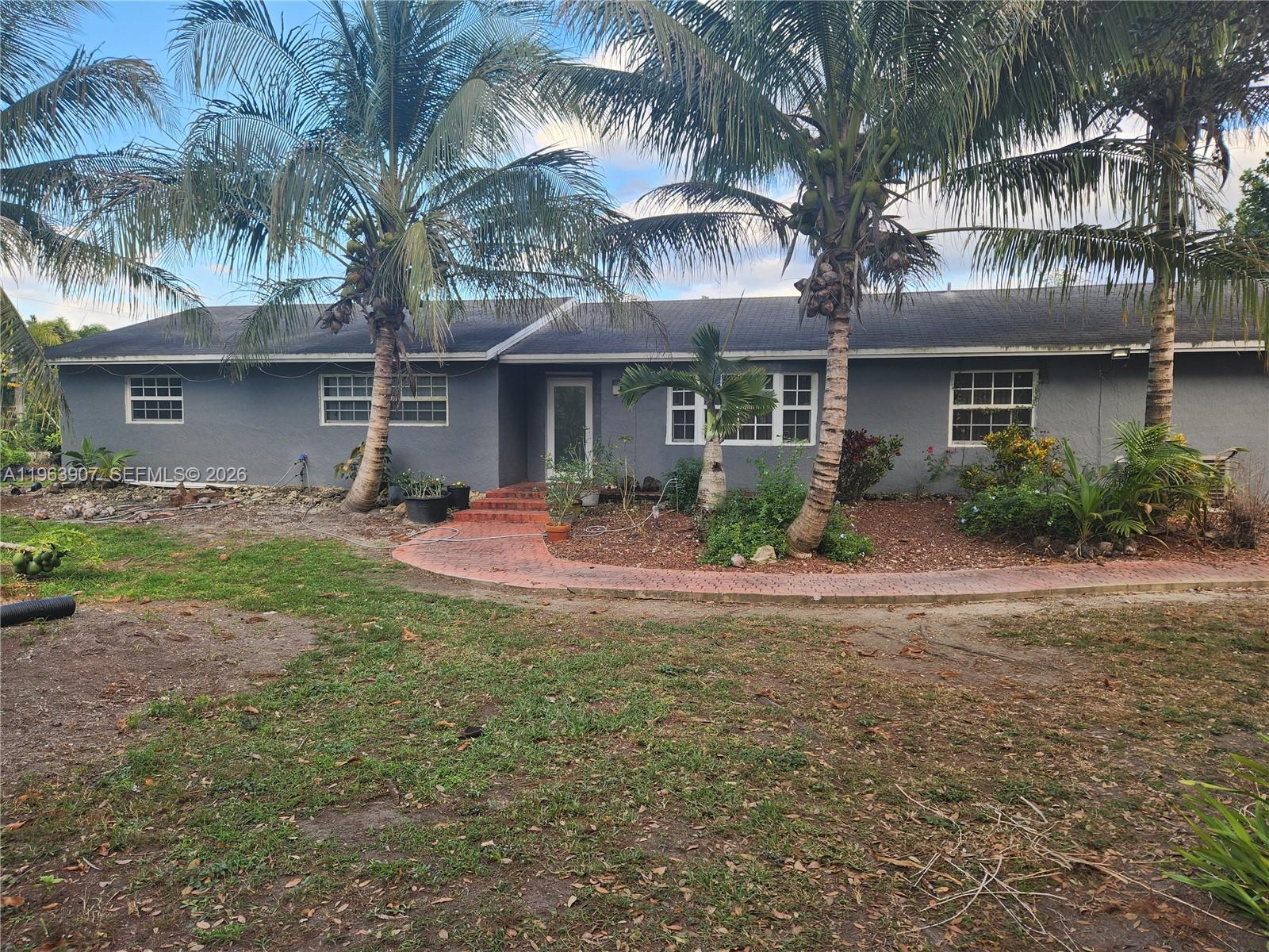 23801 Southwest 217th Avenue Homestead, FL 33031 - Photo 4 of 14 a front view of a house with yard and green space