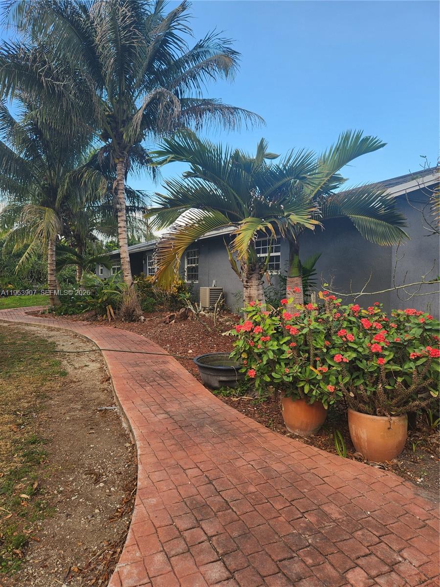 23801 Southwest 217th Avenue Homestead, FL 33031 - Photo 5 of 14 a front view of a house with a yard and a garden