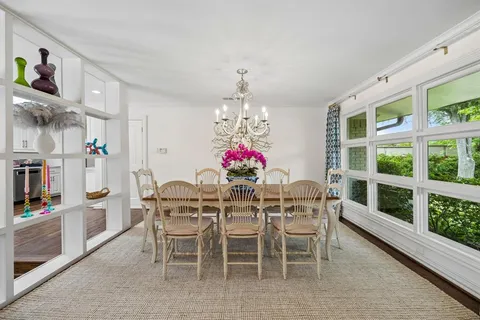 a dining room with furniture a chandelier and window