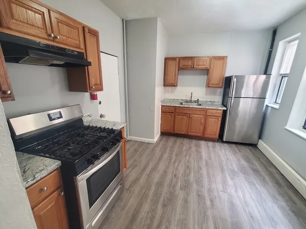 a kitchen with granite countertop a stove and a refrigerator