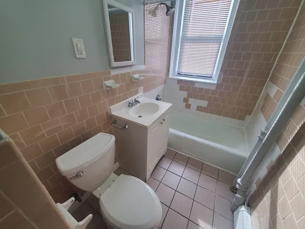 a bathroom with a toilet a sink a mirror and bathtub