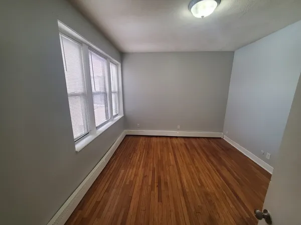a view of a room with wooden floor and window