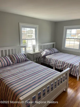 a bedroom with two beds and wooden floors