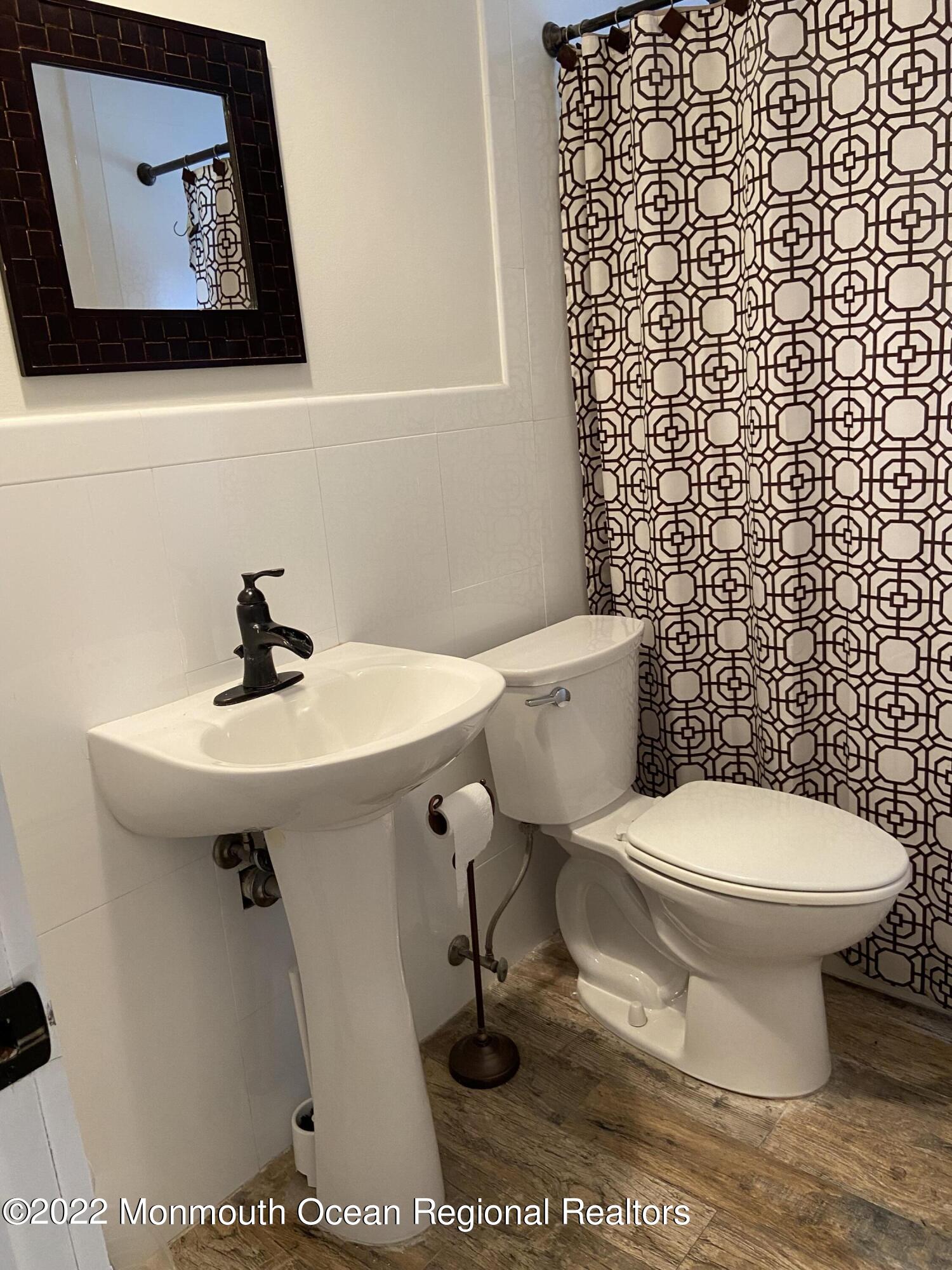 452 Marathon Court Lavallette, NJ 08735 - Photo 16 of 20 a bathroom with a sink toilet and a mirror