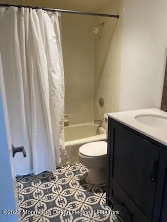 a bathroom with a sink a toilet a tub and shower