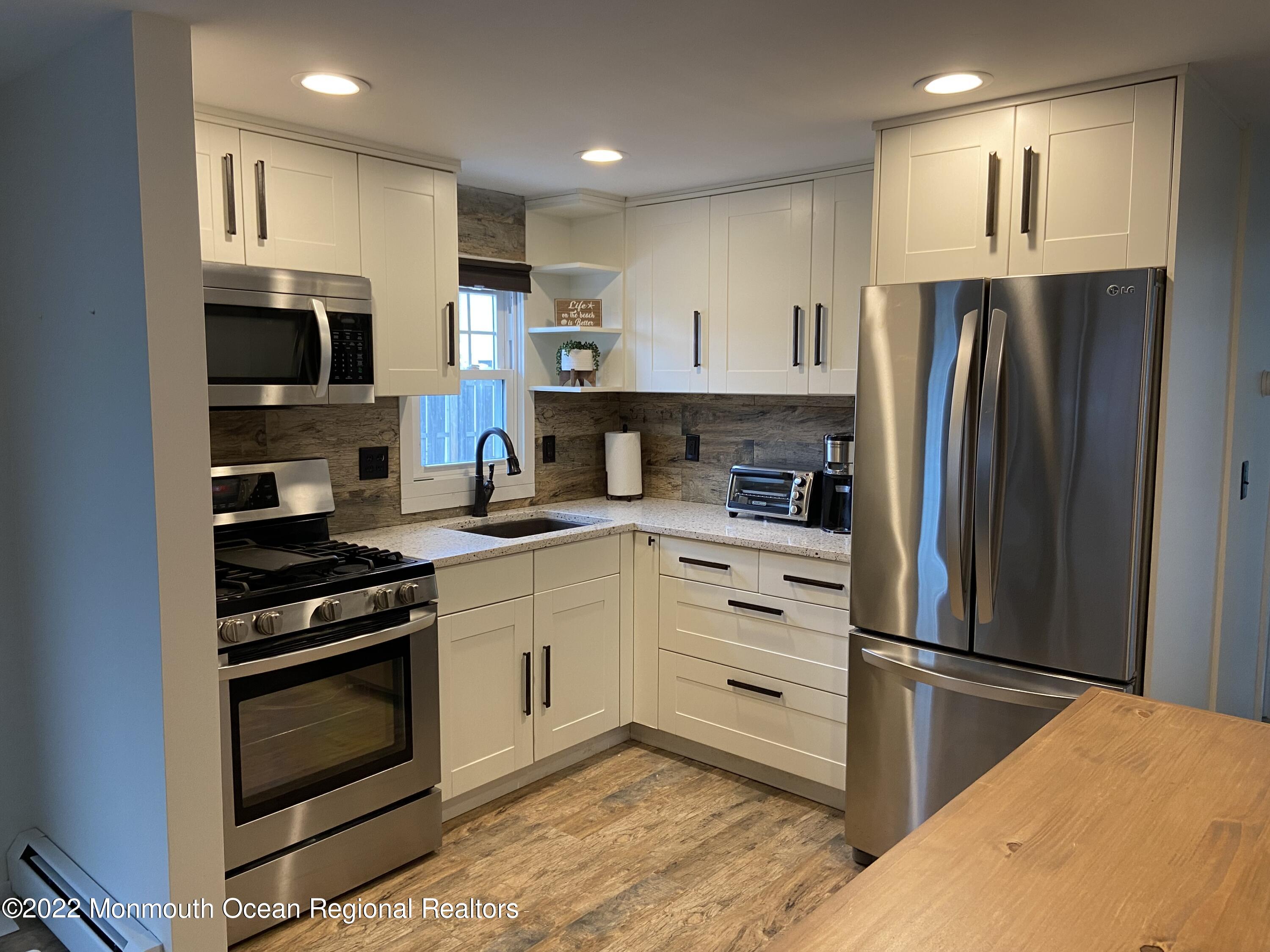 452 Marathon Court Lavallette, NJ 08735 - Photo 3 of 20 a kitchen with stainless steel appliances granite countertop a refrigerator stove and sink