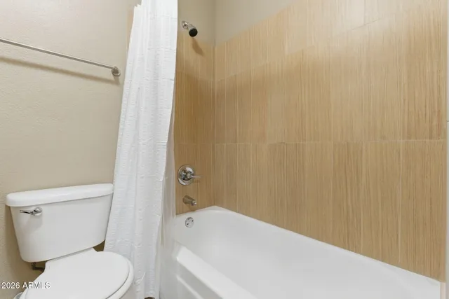 a white toilet sitting next to a bath tub