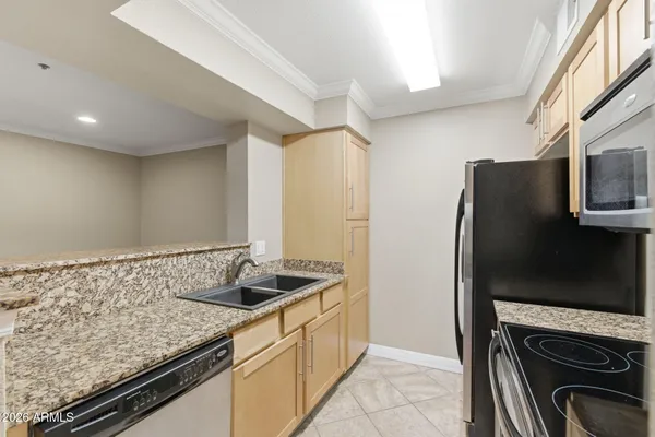 a kitchen with stainless steel appliances granite countertop a refrigerator and a stove