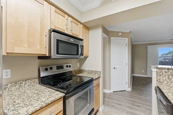 a kitchen with granite countertop a stove and a microwave