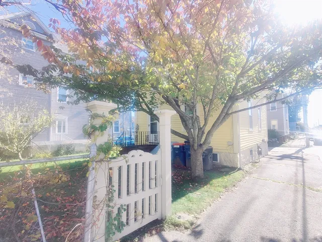 a view of a house with a yard covered with trees