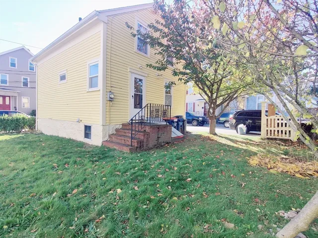 a front view of a house with a yard and trees