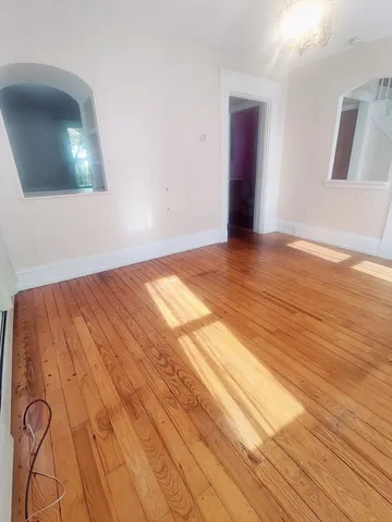 a view of a room with wooden floor and front door
