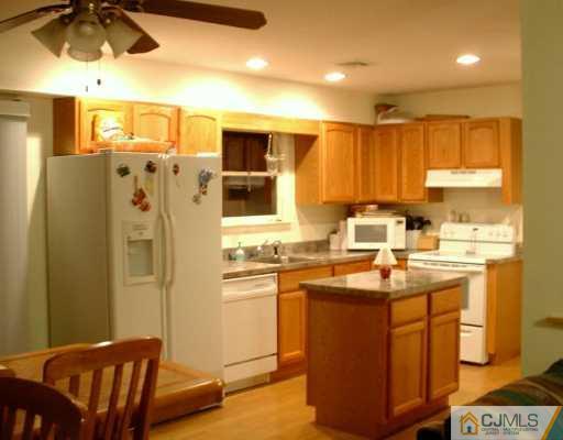 10 Windsor Road Edison, NJ 08817 - Photo 2 of 7 a kitchen with stainless steel appliances granite countertop a sink a stove a refrigerator cabinets and a dining table