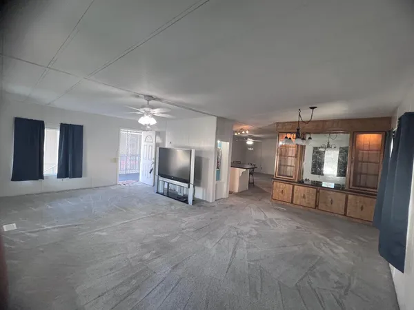 a kitchen with stainless steel appliances a sink a stove a refrigerator cabinets and a dining table