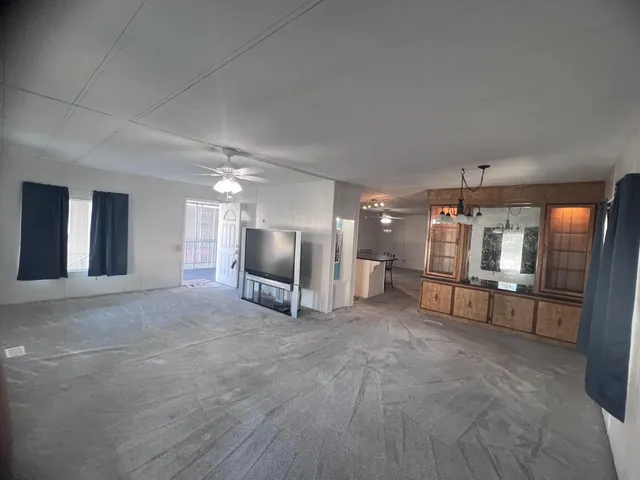 a kitchen with stainless steel appliances a sink a stove a refrigerator cabinets and a dining table