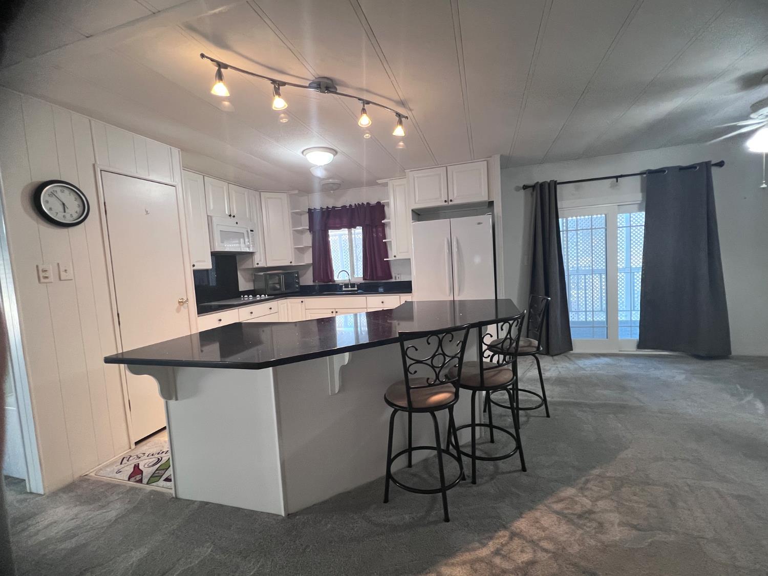 3913 Waimea Lane Modesto, CA 95355 - Photo 16 of 32 a kitchen with kitchen island stainless steel appliances a table chairs sink and cabinets
