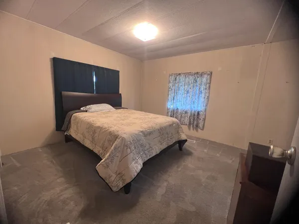 a spacious bedroom with a bed and a dresser