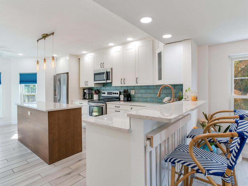 410 140th Avenue East Madeira Beach, FL 33708 - Photo 22 of 77 a kitchen with stainless steel appliances granite countertop a refrigerator sink and stove