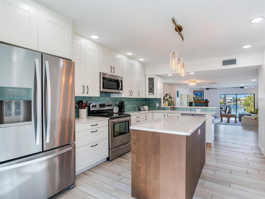 410 140th Avenue East Madeira Beach, FL 33708 - Photo 28 of 77 a large kitchen with stainless steel appliances and a refrigerator