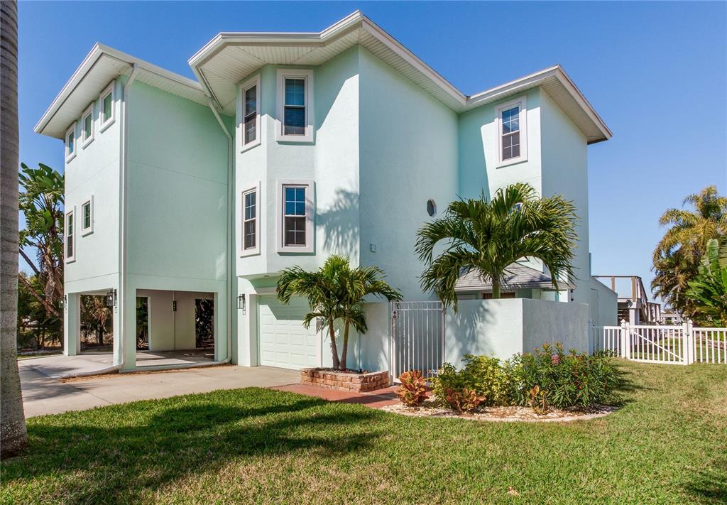 410 140th Avenue East Madeira Beach, FL 33708 - Photo 3 of 77 a front view of a house with a yard and potted plants