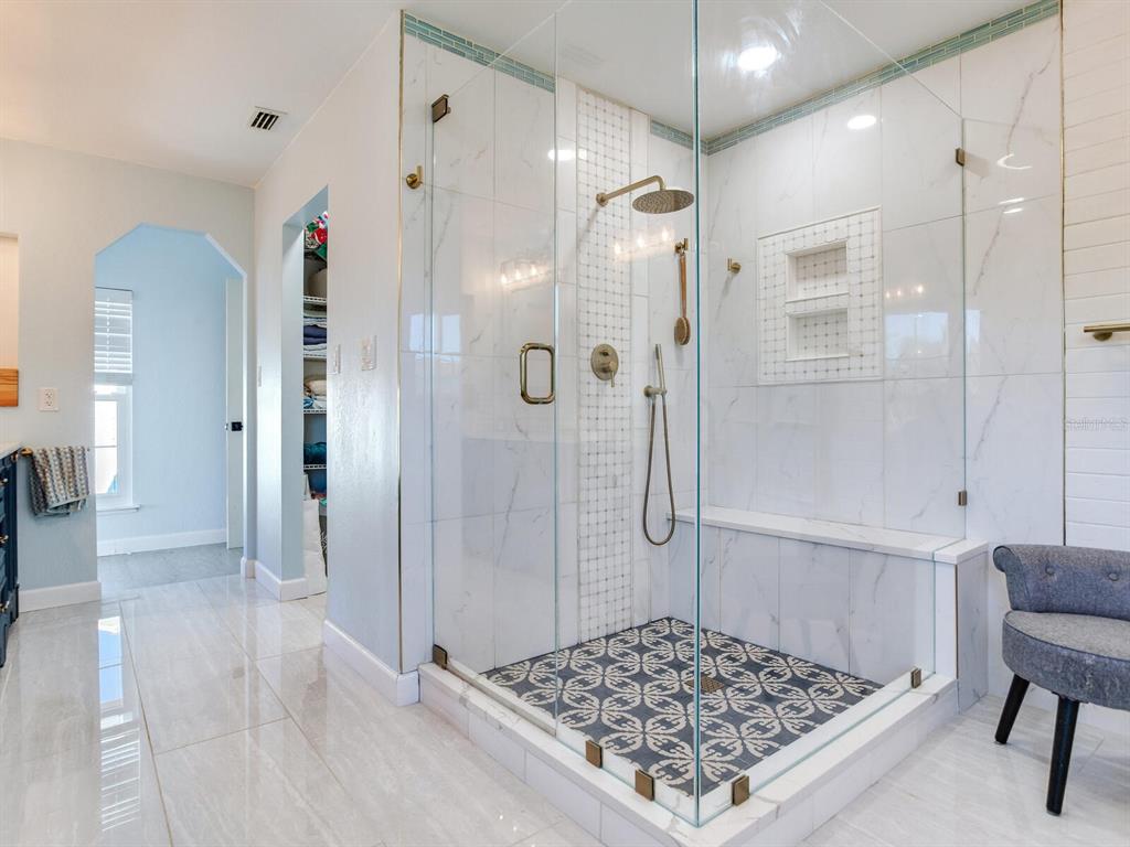 410 140th Avenue East Madeira Beach, FL 33708 - Photo 43 of 77 a bathroom with a glass shower door and a sink