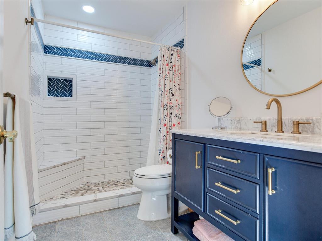 410 140th Avenue East Madeira Beach, FL 33708 - Photo 49 of 77 a bathroom with a sink a toilet and a mirror