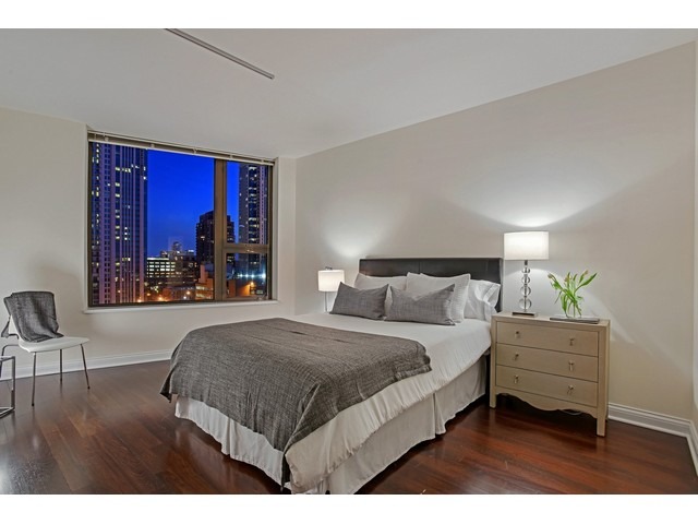 501 North Clinton Street, Unit 904 Chicago, IL 60654 - Photo 11 of 25 a bedroom with a bed a table and chair