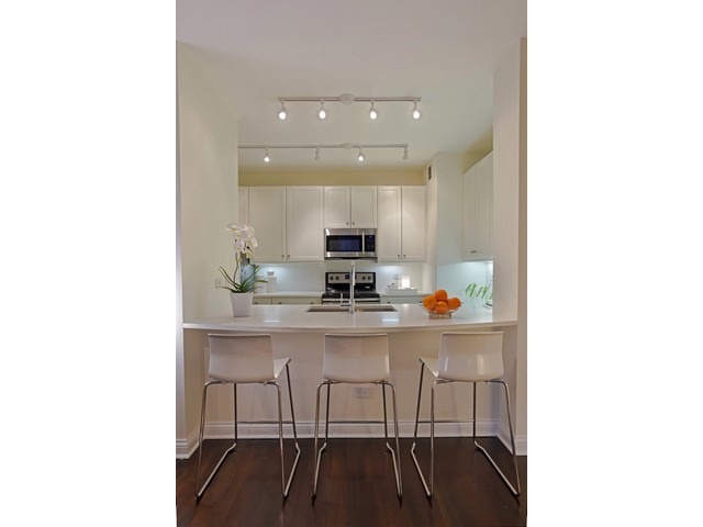 501 North Clinton Street, Unit 904 Chicago, IL 60654 - Photo 7 of 25 a living room with stainless steel appliances kitchen island granite countertop a sink and cabinets