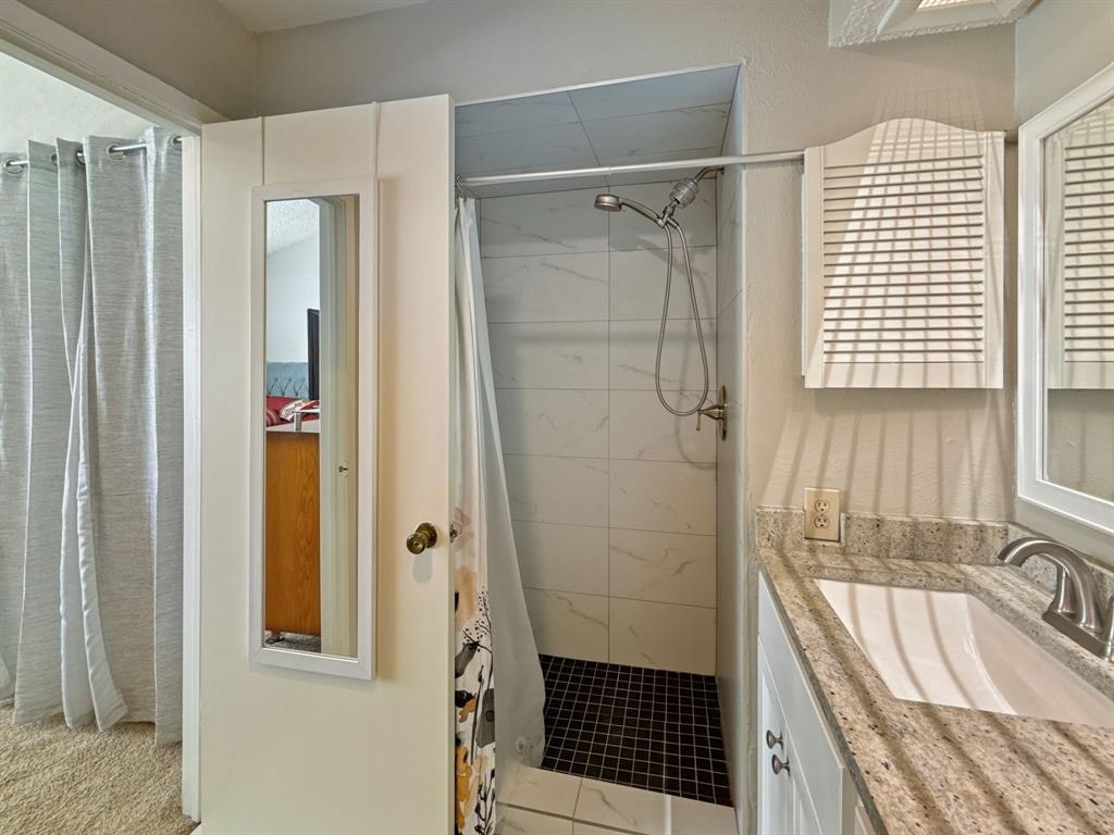 214 Samuel Boulevard, Unit 1H Coppell, TX 75019 - Photo 11 of 21 a bathroom with a sink and a shower