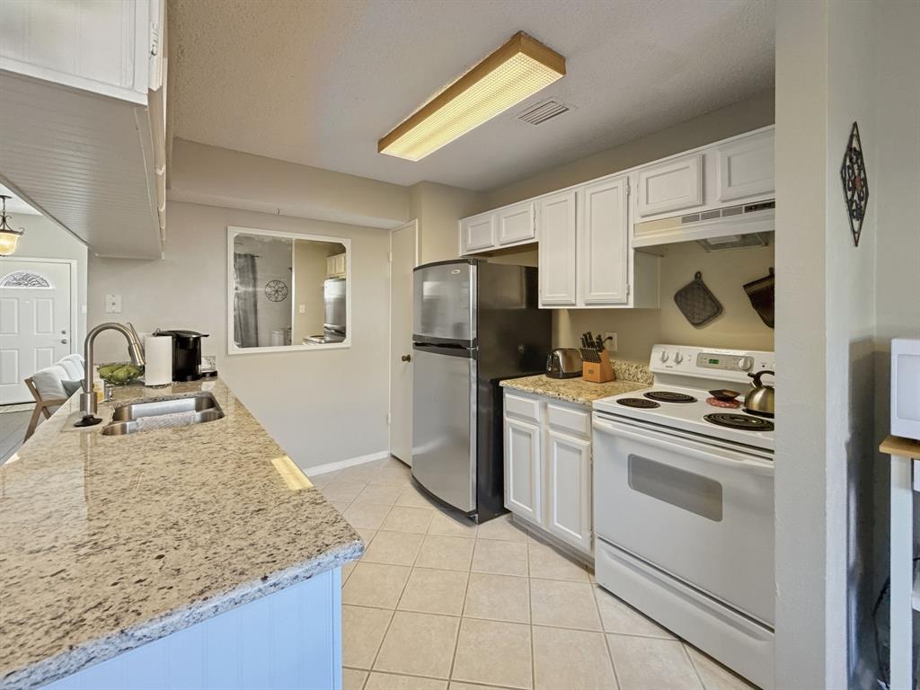 214 Samuel Boulevard, Unit 1H Coppell, TX 75019 - Photo 18 of 21 a kitchen with a sink stove and refrigerator