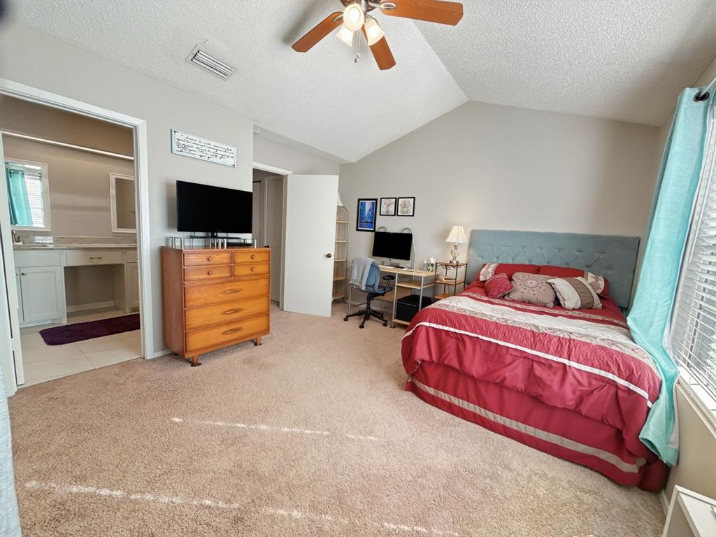214 Samuel Boulevard, Unit 1H Coppell, TX 75019 - Photo 9 of 21 a spacious bedroom with a bed and a flat screen tv