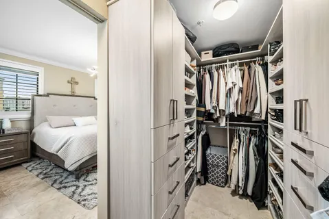 a view of walk in closet with clothes and shoes