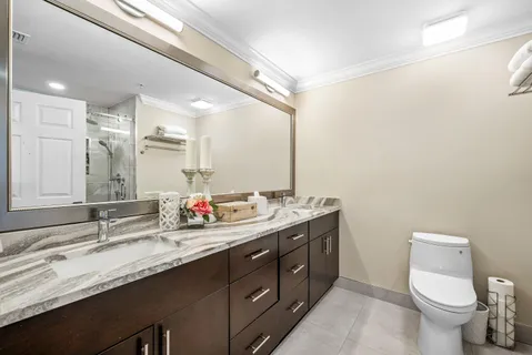 a bathroom with a double vanity sink toilet and a mirror