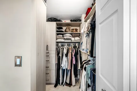 a view of walk in closet with clothes