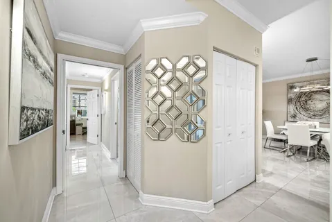 a view of a hallway with bathroom and wooden floor