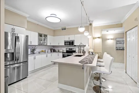 a kitchen with stainless steel appliances kitchen island a refrigerator sink and microwave