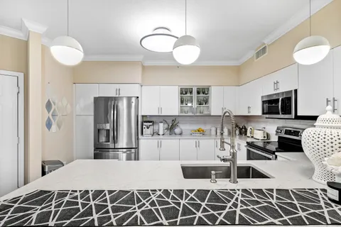 a kitchen with granite countertop a refrigerator stove top oven and sink