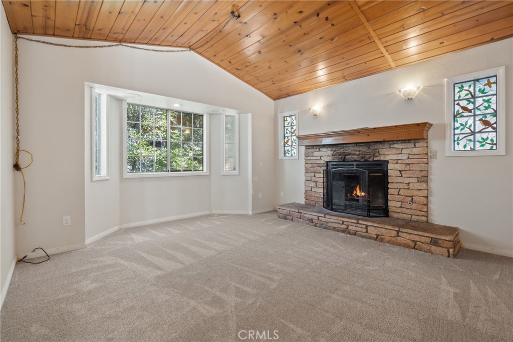 23561 Short Way Crestline, CA 92325 - Photo 5 of 18 an empty room with a fireplace and windows