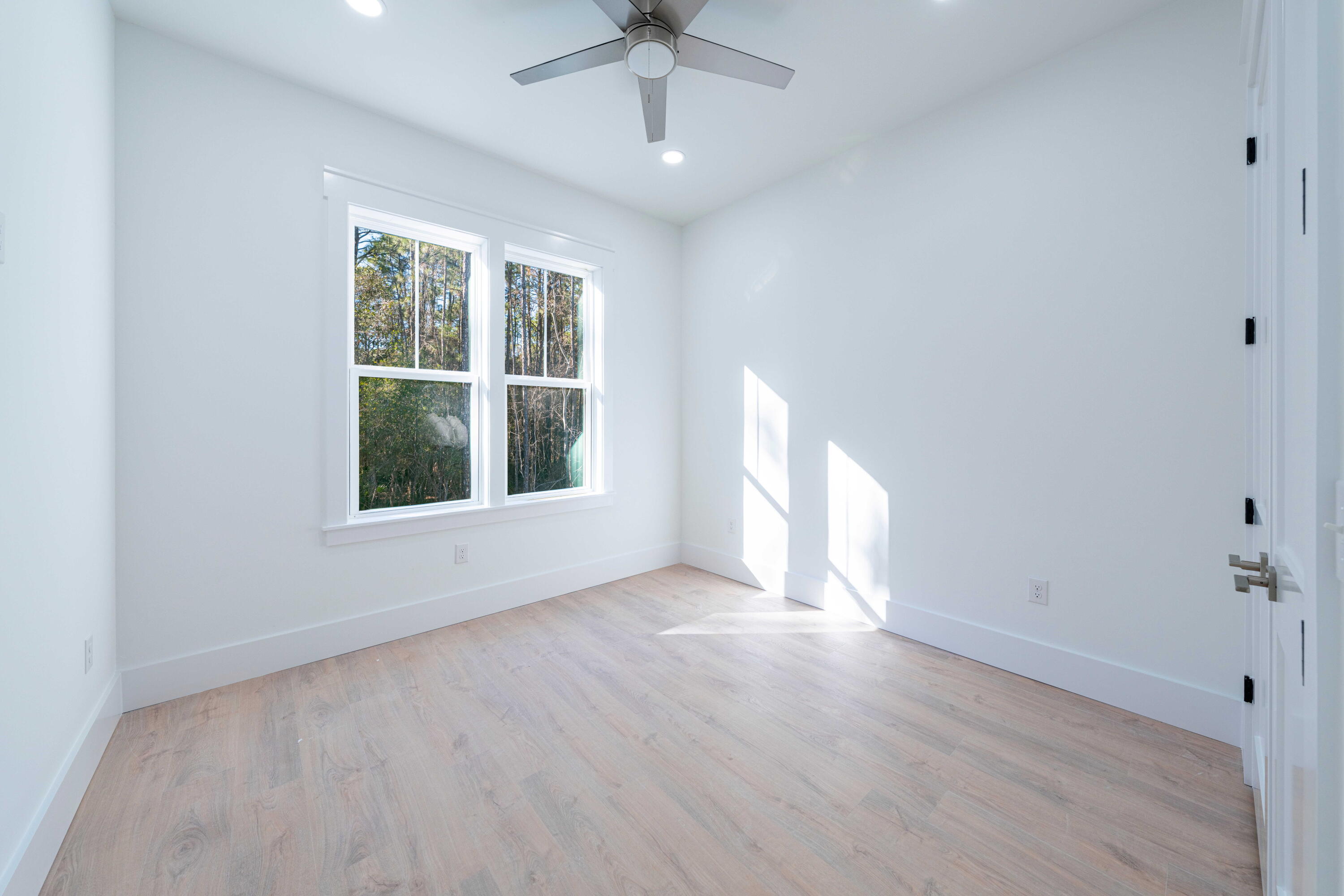 142 4th Street Santa Rosa Beach, FL 32459 - Photo 15 of 26 wooden floor in an empty room with a window