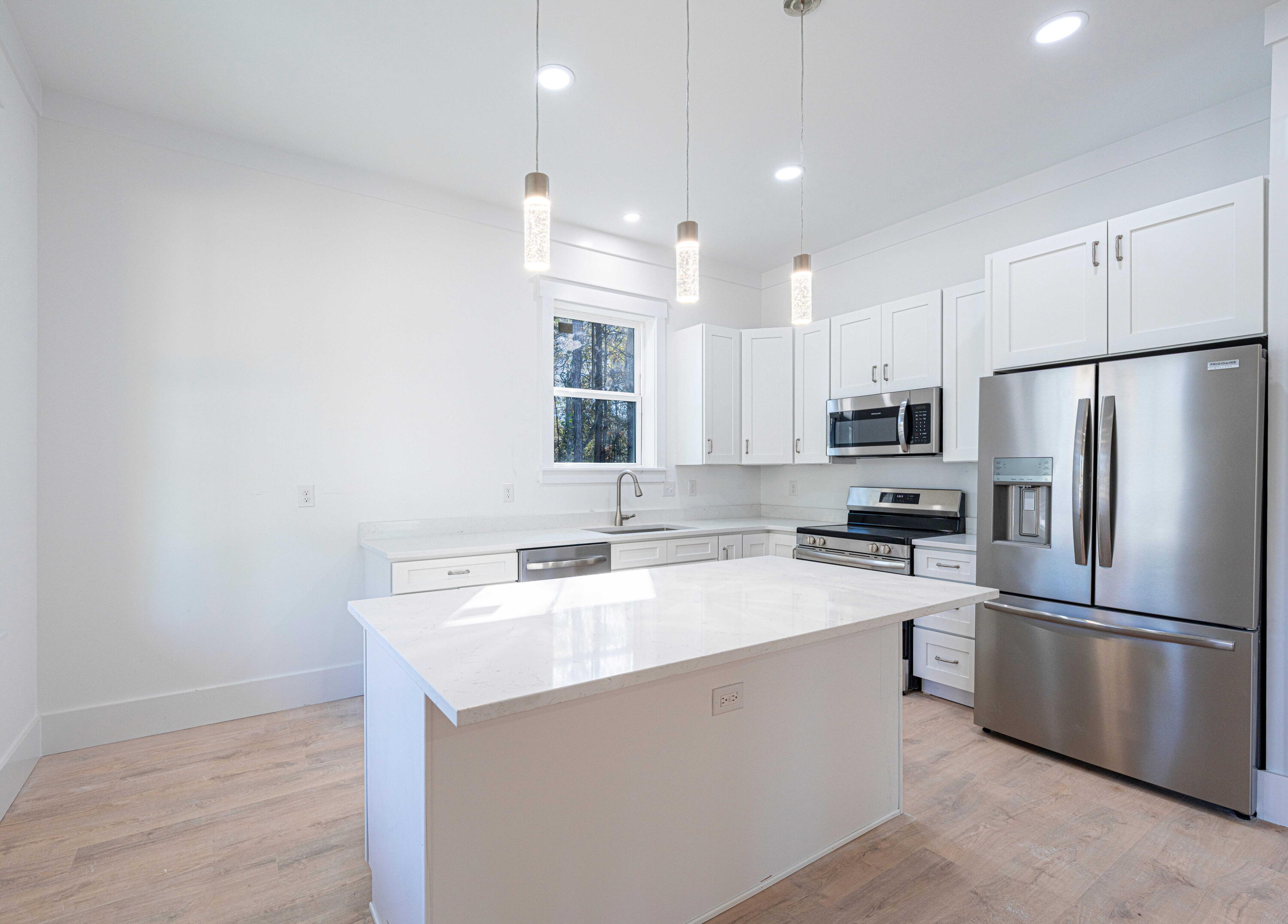 142 4th Street Santa Rosa Beach, FL 32459 - Photo 6 of 26 a kitchen with a refrigerator a sink and a microwave
