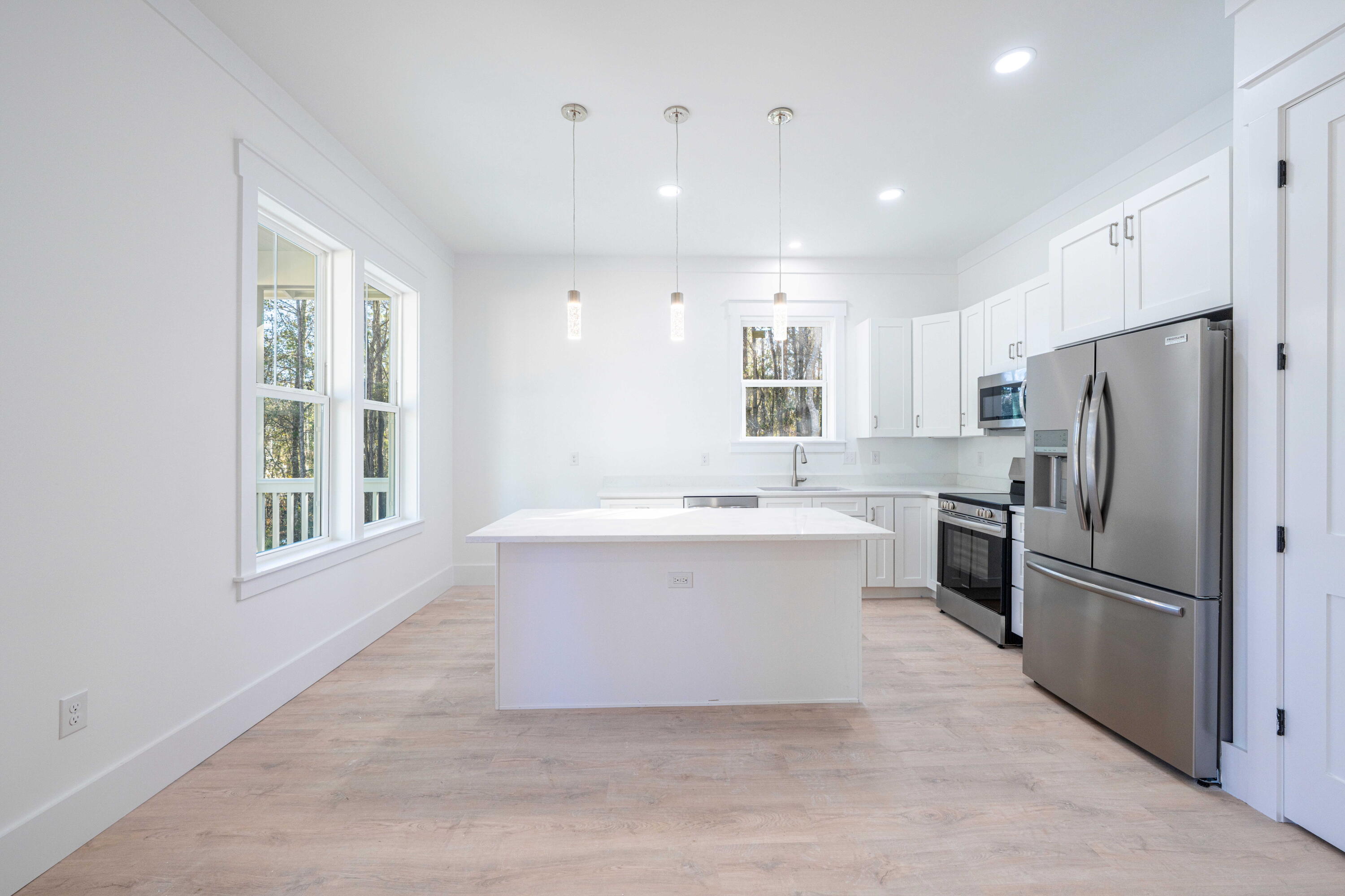 142 4th Street Santa Rosa Beach, FL 32459 - Photo 7 of 26 a large white kitchen with a refrigerator a sink dishwasher a stove and a refrigerator with wooden floor