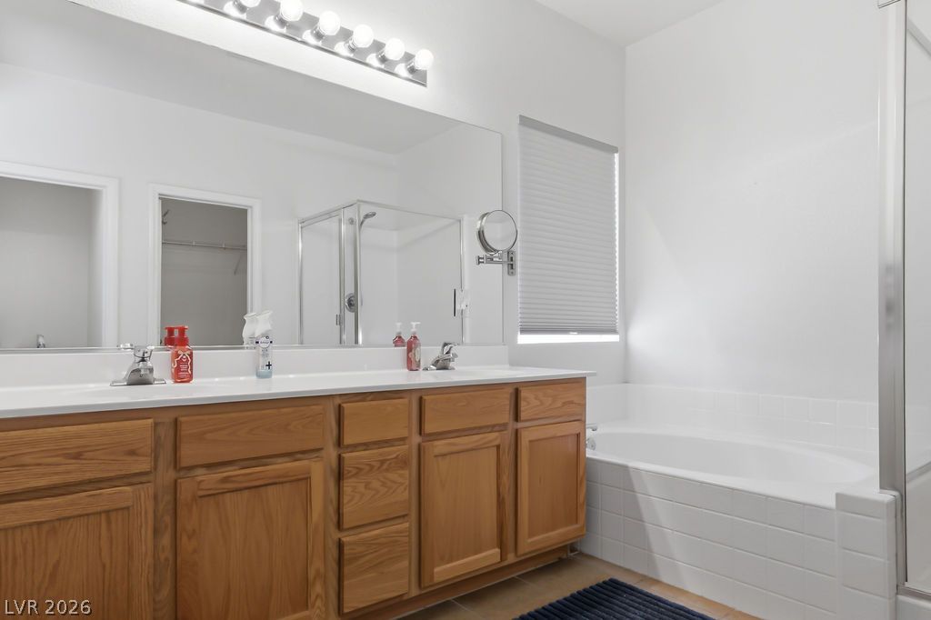 754 Solitude Point Avenue Henderson, NV 89012 - Photo 30 of 38 A well-appointed bath features a dual vanity and a deep soaking tub, perfect for relaxation.