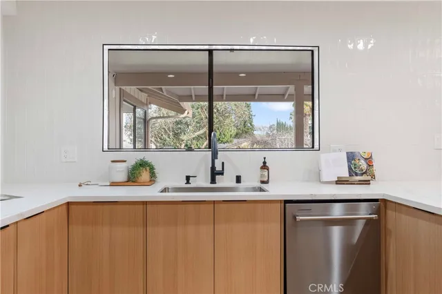 a kitchen with stainless steel appliances granite countertop a refrigerator a stove and a sink with wooden floor