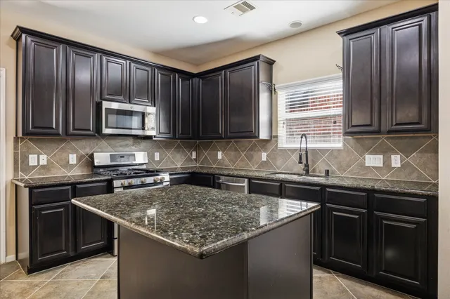 a kitchen with a sink stove top oven and microwave