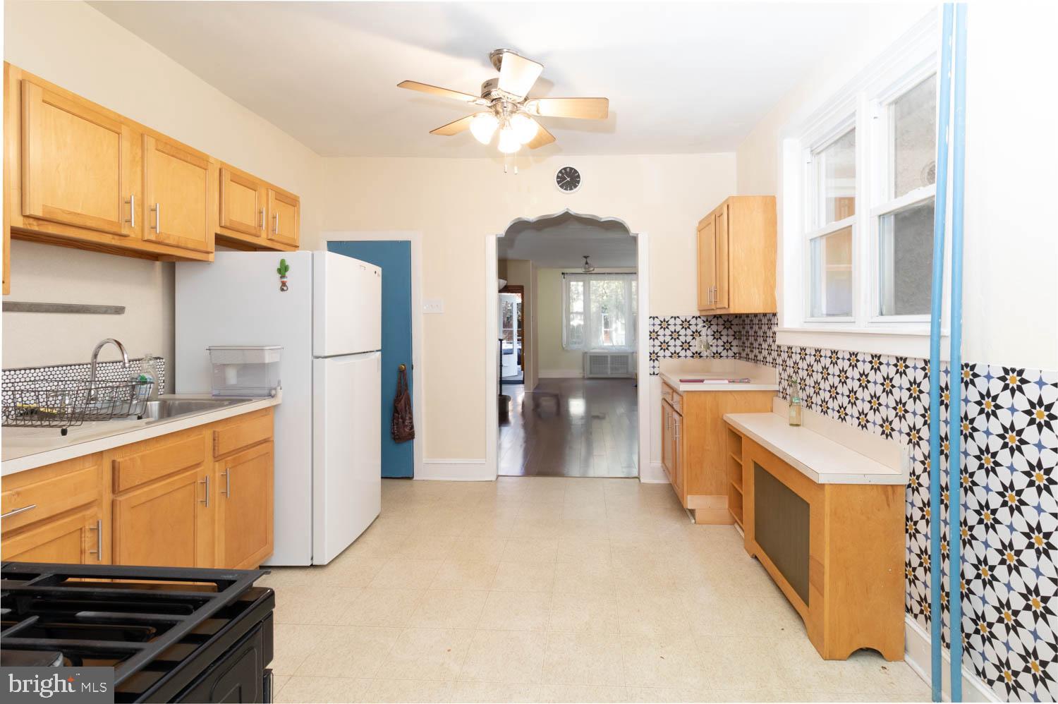 820 Tasker Street Philadelphia, PA 19148 - Photo 9 of 25 a kitchen with stainless steel appliances kitchen island granite countertop a refrigerator a stove and a sink with cabinets